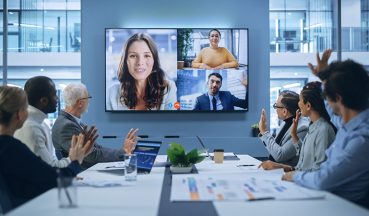 Video Conference Call in Office Boardroom Meeting Room: Executive Directors Talk with Group of Multi-Ethnic Entrepreneurs, Managers, Investors. Businesspeople Discuss e-Commerce Investment Strategy